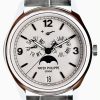 Close-up of a Patek Philippe wristwatch with day and month subdials, a date window, and a moon phase indicator on a silver dial.