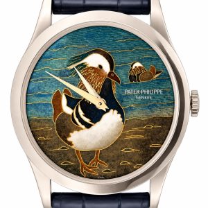 Luxury wristwatch with a blue enamel dial featuring a stylized bird in gold tones and the brand 'Patek Philippe Genève' on the face, navy strap visible.
