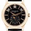 Rose gold Patek Philippe watch with black dial, black leather strap, date window at 12, and moon-phase subdial at 6 o'clock.