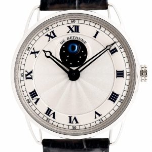 Close-up of a De Bethune wristwatch with Roman numerals, moon phase at center, and black hands on a white guilloché dial with a black leather strap.