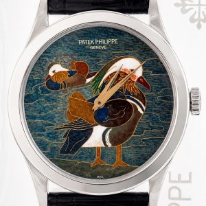 Patek Philippe wristwatch with an enamel dial showing a colorful bird; silver case, black leather strap.
