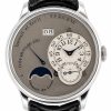 Close-up of a metallic wristwatch showing hours and minutes on a small dial, a date window reading 08, and a moon phase indicator.