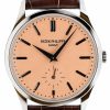 Patek Philippe wristwatch with peach dial, black baton markers, and brown leather strap, showing a small seconds subdial at 6 o'clock.