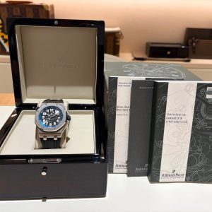 Audemars Piguet wristwatch in an open black display box on a white surface with brochures to the right in a showroom setting.